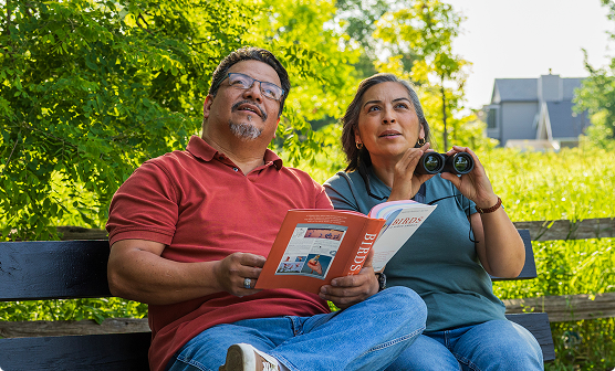 couple sitting on bench reading a brochure