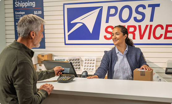 Postal employee a customer at a post office counter.