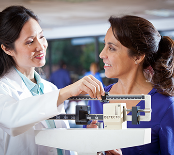 doctor weighing patient on scale