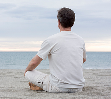 Man meditating on the beach